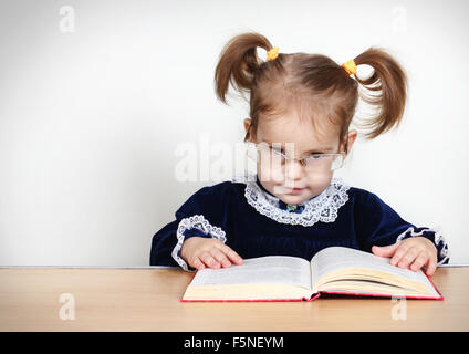 Funny little girl reading book Stock Photo