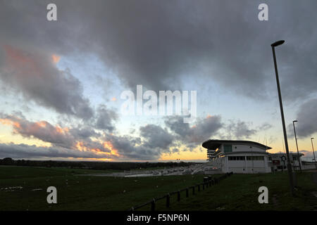 Epsom Downs, Surrey. 7th November 2015. After a day of wind and rain the storm finally passed just before dusk at Epsom Downs Surrey. The glow of the setting sun behind clouds at the grandstand. Credit:  Julia Gavin UK/Alamy Live News Stock Photo