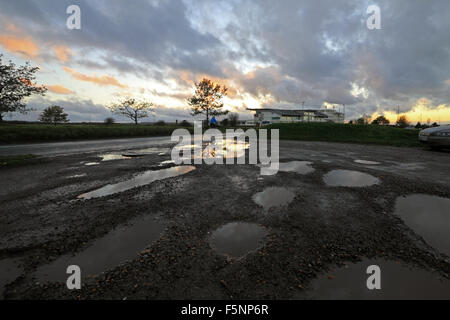 Epsom Downs, Surrey. 7th November 2015. After a day of wind and rain the storm finally passed just before dusk at Epsom Downs Surrey. The warm glow of the setting sun reflected in the huge puddles in the car park behind the grandstand. Credit:  Julia Gavin UK/Alamy Live News Stock Photo