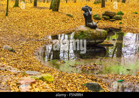Mermaid Statue on Stone among Pond In Autumn Park Stock Photo