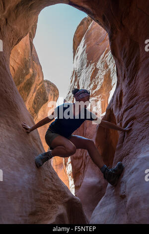 Girl Hiker Climbing Narrow Park of Peekaboo Gulch Canyon Stock Photo