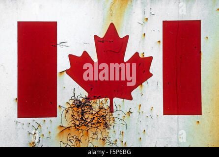 Canada's national flag, painted on a grungy, white, rusting metal wall. Stock Photo