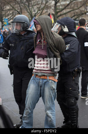 A counter-demonstrator is arrested during a demonstration by the Alternative für Deutschland (AfD) political party in Berlin. Around 5000 supporters of the AfD took part in the march and rally calling on German Chancellor Angela Merkel to halt the influx of refugees into the country. Around one million refugees from the Middle East and north Africa arrived in Germany during 2015, 50,000 of whom came to Berlin. Stock Photo