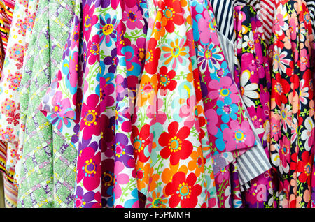 Colorful rolls of patterned fabric on sale at a market Stock Photo