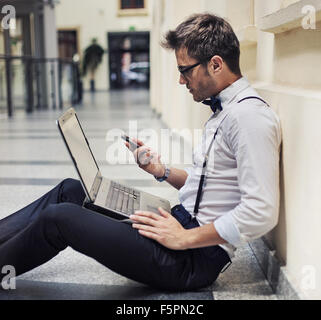 Busy elegant businessman working in the lobby Stock Photo