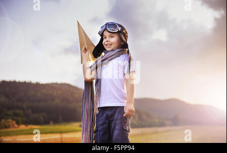 Cute little pilot holding a paper plane Stock Photo