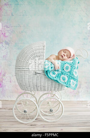 Cute child sleeping in the wicker pram Stock Photo