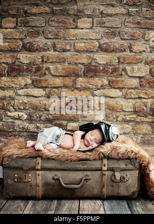 Little cute pilot sleeping on the suitcase Stock Photo