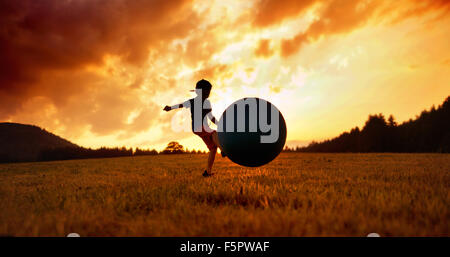 Little child playing football on the meadow Stock Photo