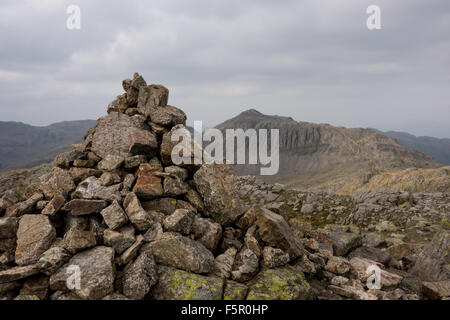 the summit cairn of crinkle crags with bowfell in the distance Stock Photo