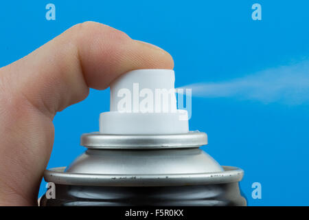 Aerosol can being sprayed against a black background Stock Photo - Alamy