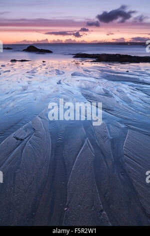 Sand patterns on Mouthwell beach created by the receding tide at sunset, Hope Cove, Devon. Stock Photo