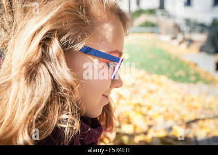 Smiling Beautiful blond teenage girl in glasses, closeup profile outdoor portrait Stock Photo