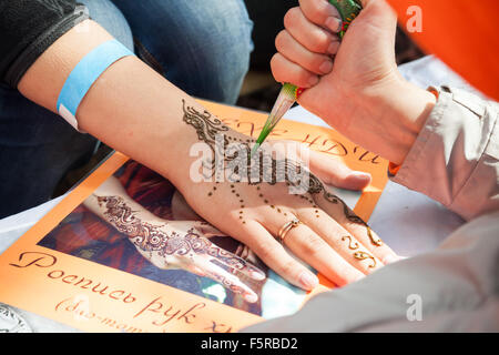 Saint-Petersburg, Russia - July 19, 2015: henna paste or mehndi application on woman hand. Traditional Indian natural skin decor Stock Photo