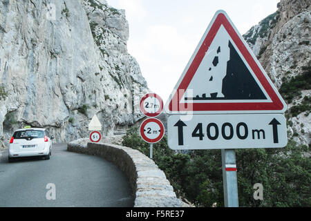car,on,winding,windy,road,with,rock,fall,sign,Narrow road south of Quillan in Aude,Galamus,Gorge,Gorges de,limestone,cliffs,South,of,France, Stock Photo