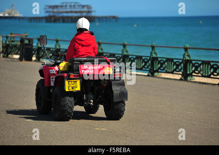 A coastguard rides along the Brighton seafront on a quad bike. Stock Photo