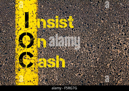 Concept image of Business Acronym IOC as Insist On Cash written over road marking yellow paint line. Stock Photo