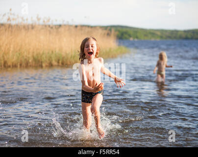 Sweden, Vastergotland, Lerum, Lake Aspen, Boy (8-9) and girl (6-7) playing in lake