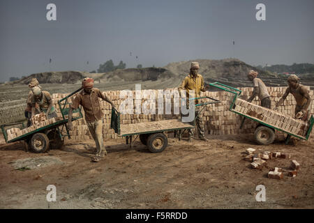 Dhaka, Bangladesh. 9th Nov, 2015. Nov 09, 2015 - Dhaka, Bangladesh - Workers are working in a brickfield where environment is so dusty.The world is going through a speedy urbanization and Bangladesh is not an exception from this. Such rapid urbanization generates a massive demand for bricks as it is one of the key ingredients to build concrete structure. To meet this growing need, numbers of brick making field have been increasing at an alarming rate in Bangladesh. Most of them took place in farming lands which causes reduction of agricultural production. We know that burning coal causes t Stock Photo