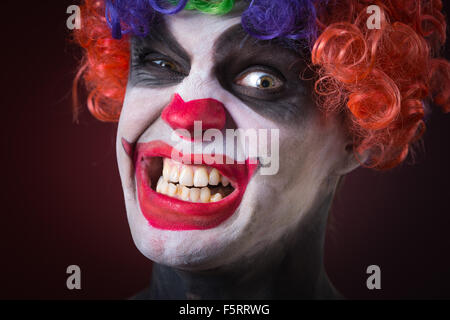 Evil Spooky Clown Portrait on dark background. expressive man Stock Photo