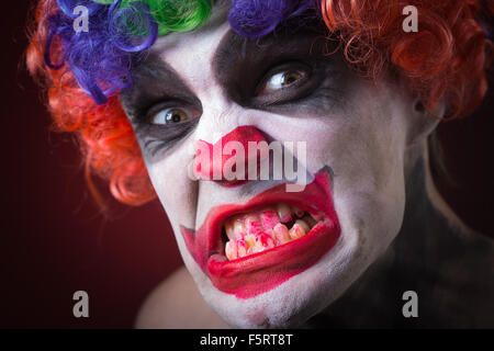 Evil Spooky Clown Portrait on dark background. expressive man Stock Photo