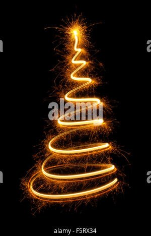 Sparkling spiral as a magical Christmas tree with glowing top on black background Stock Photo