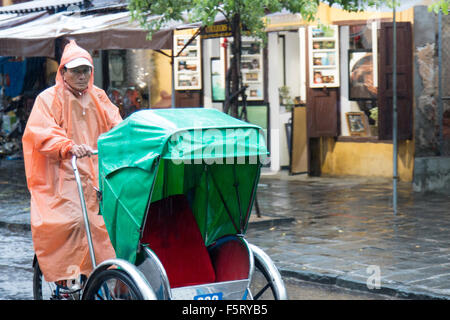 Hoi An old town in Vietnam. Wet season and heavy rains in the town. rickshaw rider Stock Photo