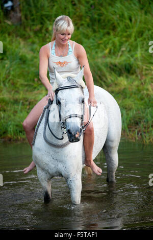 A barefoot woman riding a horse on a beach Stock Photo - Alamy