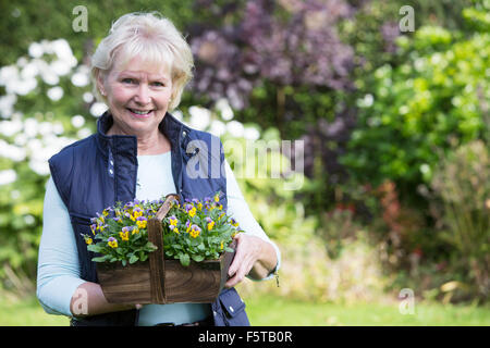 Senior woman working in the garden with mower Stock Photo - Alamy