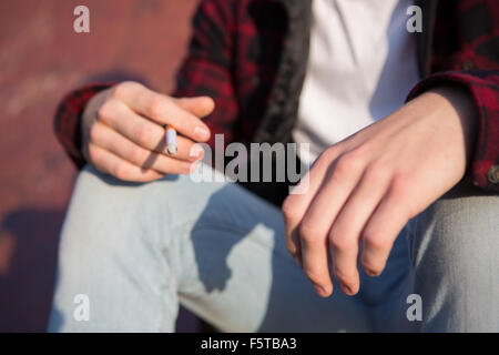 Close Up Of Teenage Boy Smoking Cigarette Outdoors Stock Photo