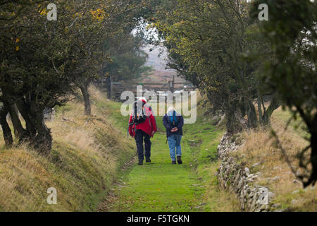 An elderly man and woman walking along a footpath above Snailbeach on the Stiperstones, Shropshire. Stock Photo