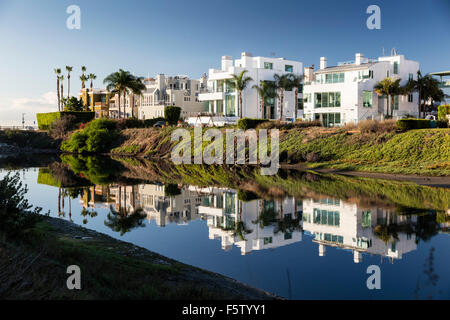 Beach houses in Marina del Rey, Los Angeles, California reflected in the mirror-like Ballona Lagoon canal. Early morning light. Stock Photo
