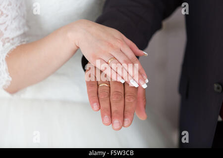 Gold wedding rings on the hands of the newlyweds Stock Photo