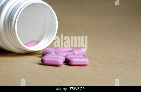 Pink Pills Spilled From A White Bottle On A Blue Background. Health 