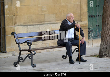 Old man sitting on bench in Ubeda Spain Stock Photo