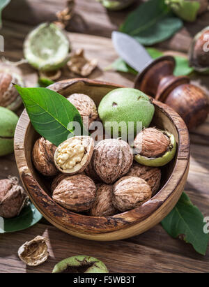 Walnuts in the wooden bowl on the table. Stock Photo