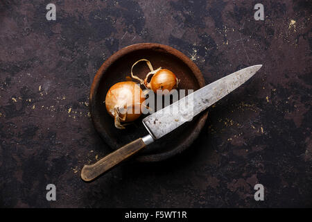 Raw bulb onion and Vintage Kitchen Knife on black background Stock Photo