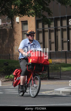 Postman on his bike Stock Photo