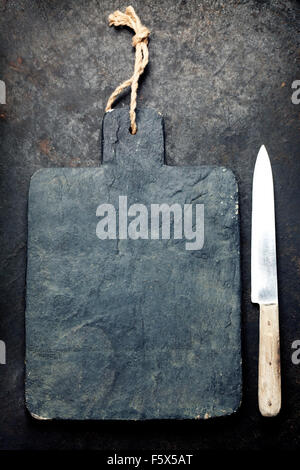 vintage cutting board and knife with space for text on old metal background, close-up Stock Photo
