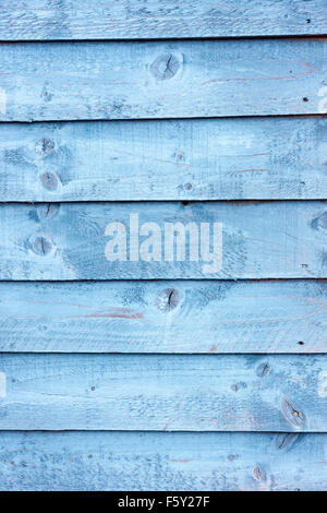 Weathered wooden boards on the side of a Hull of a fishing boat. Blue paint that has faded and weathered in time. Stock Photo