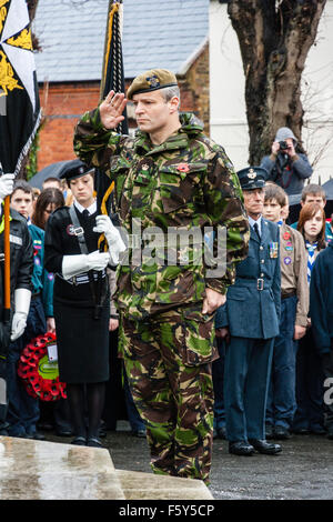 England, Ramsgate. Remembrance Day. Senior military officer wearing camouflage uniform saluting at war memorial during ceremony in the rain. Stock Photo