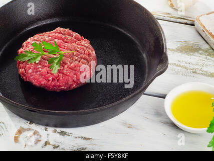 Raw beef burger patty on a pan. Selective focus Stock Photo
