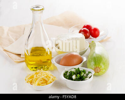 Vegetable tart ingredients. Dough, olive oil, feta, cheese,fresh vegetables Stock Photo