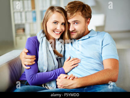 Happy young couple relaxing on sofa at home Stock Photo