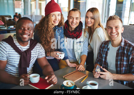 Group of happy teenagers having coffee in cafe Stock Photo