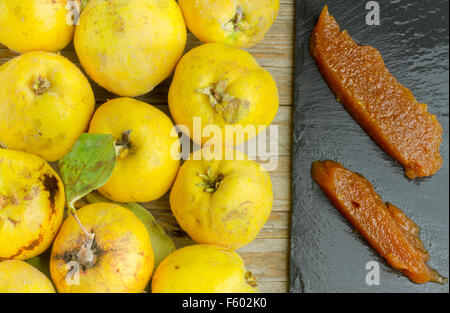 Spanish quince paste on a slate plate with quince fruits on wooden background Stock Photo