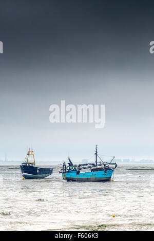 Cockle boats moored on the mudflats at Leigh on Sea in Essex. Stock Photo