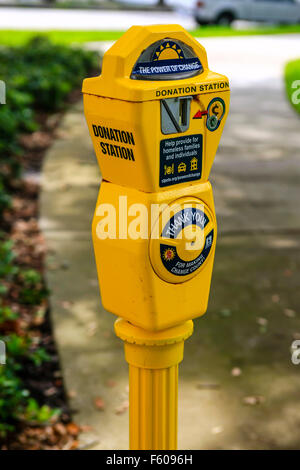 Bright yellow Donation Station retired Parking Meter seen in the park in St. Petersburg FL Stock Photo