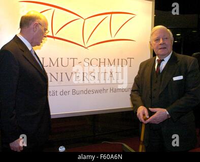Defense Minister Peter Struck and former Chancellor Helmut Schmidt (R) are standing in front of a sign with the new logo of the university during the ceremony for the naming of the Bundeswehr University to 'Helmut Schmidt Universität' on 16 December 2003 in Hamburg.