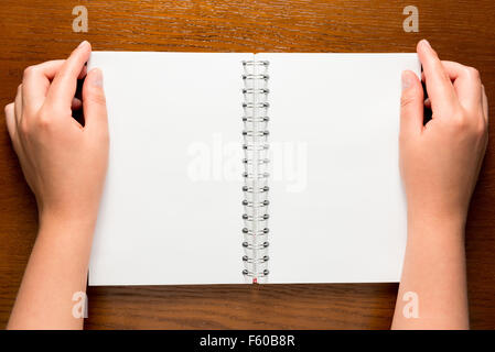 notepad with clean sheets and a top view of female hands Stock Photo